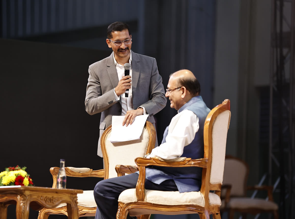 Chinmay in a fireside chat with a guest on stage